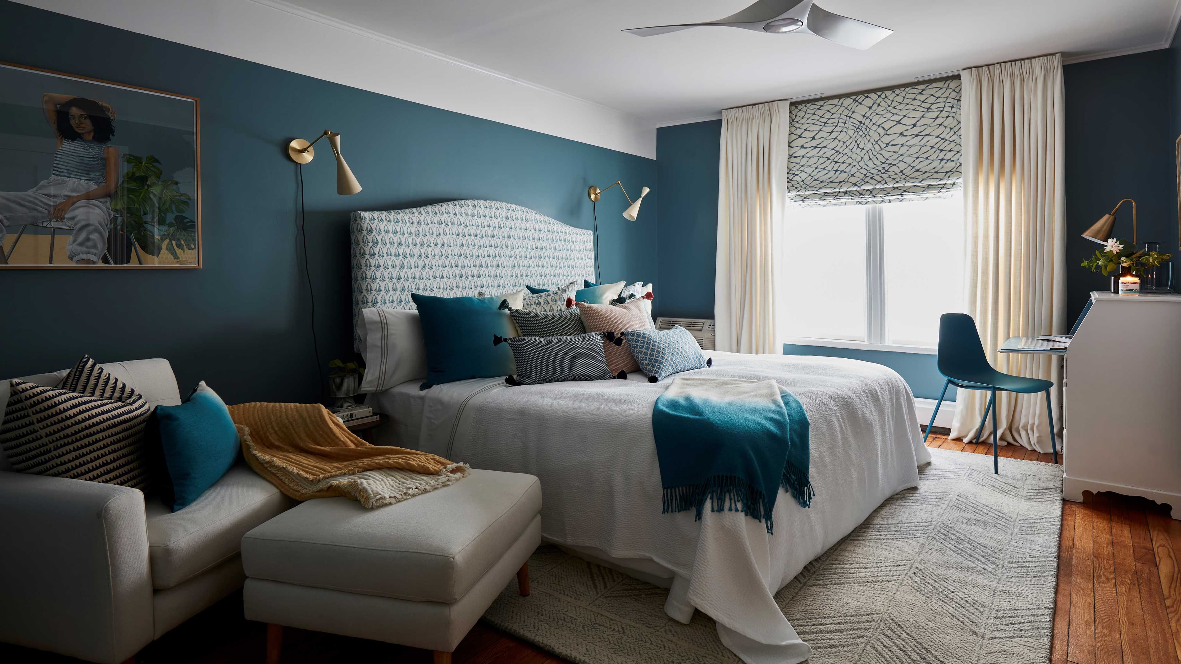 Contemporary bedroom with blue walls and mixed patterns.
