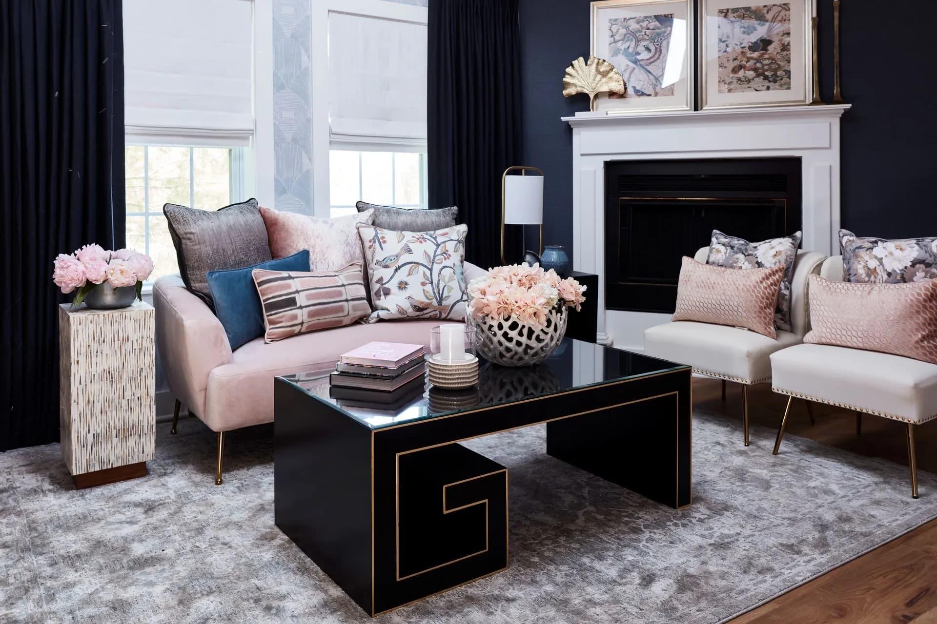 Modern living room with pink sofa, black fireplace, and two armchairs.