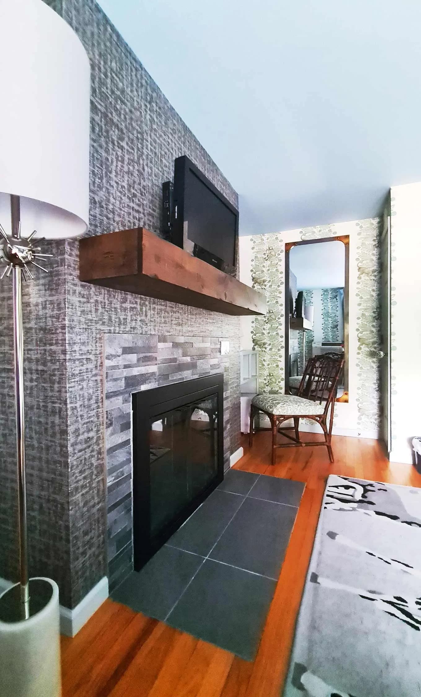Modern living room with fireplace, TV, and patterned wallpaper.