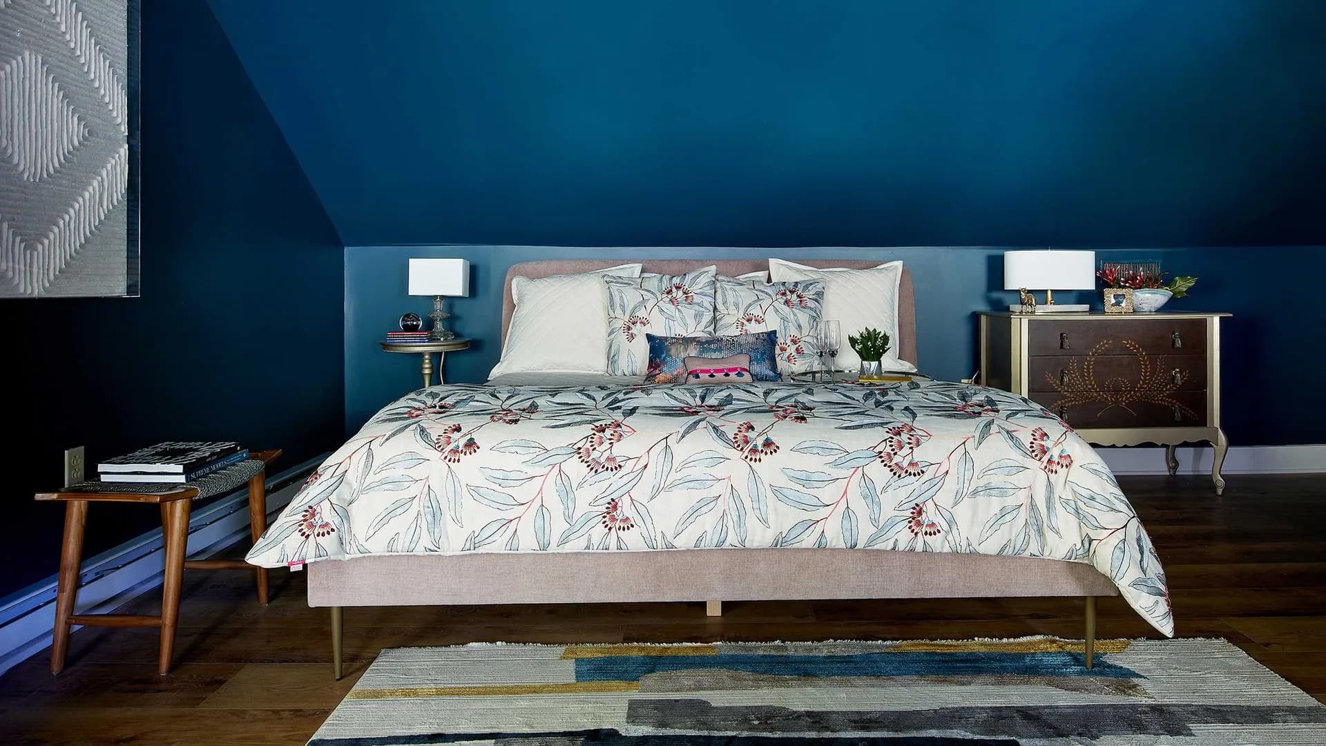 Blue-toned bedroom with patterned bedding and sloped ceiling.