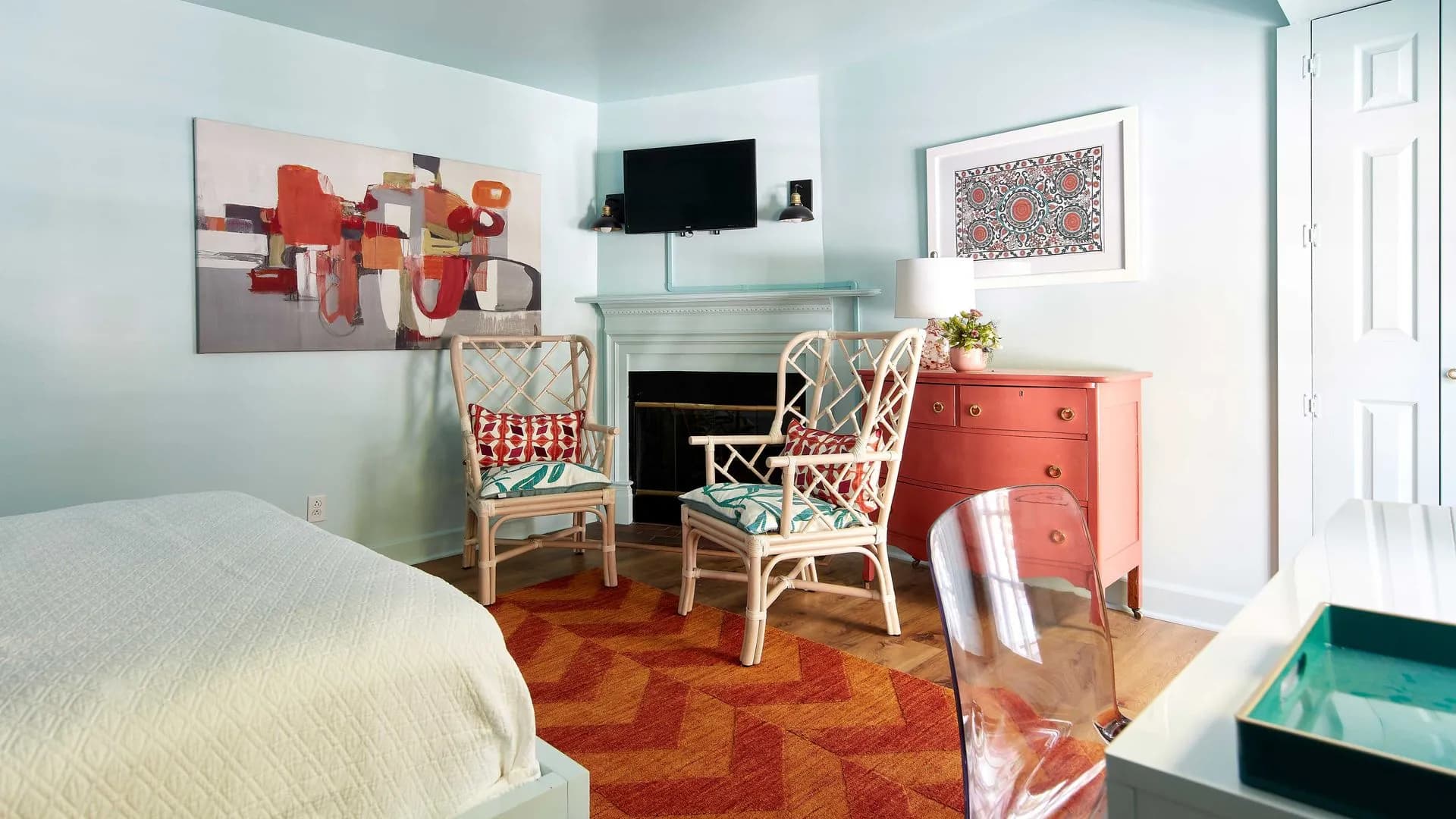 Cozy sitting area with two chairs, a fireplace, and a TV on the wall.