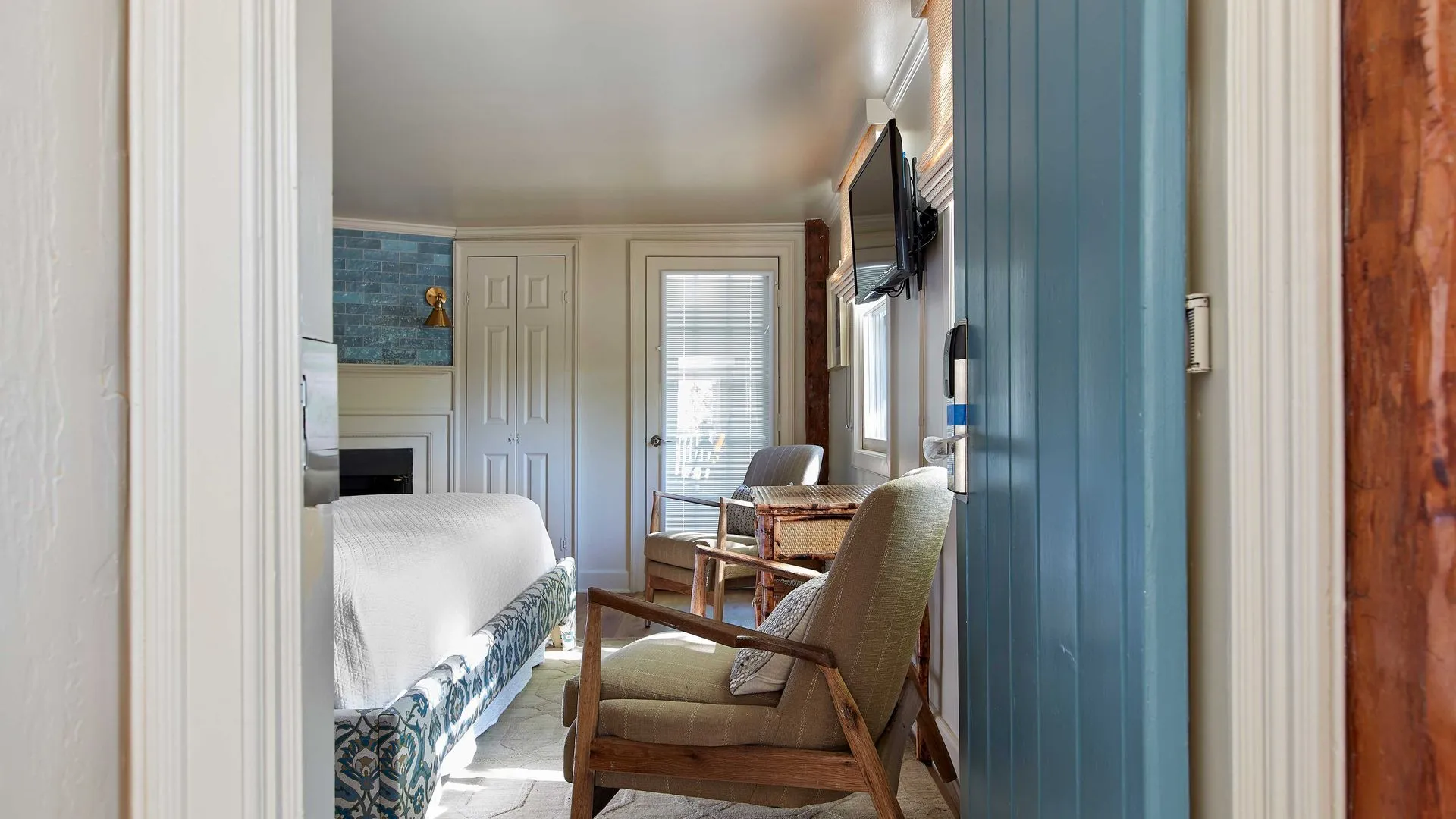 seating area of 2 chairs at the foot of the bed