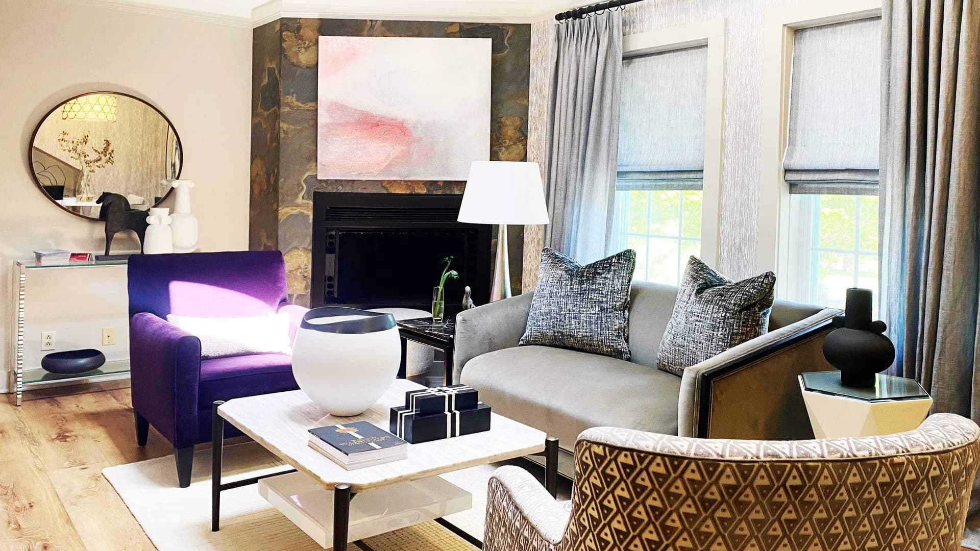 Living room with purple armchair, gray sofa, and stone fireplace.