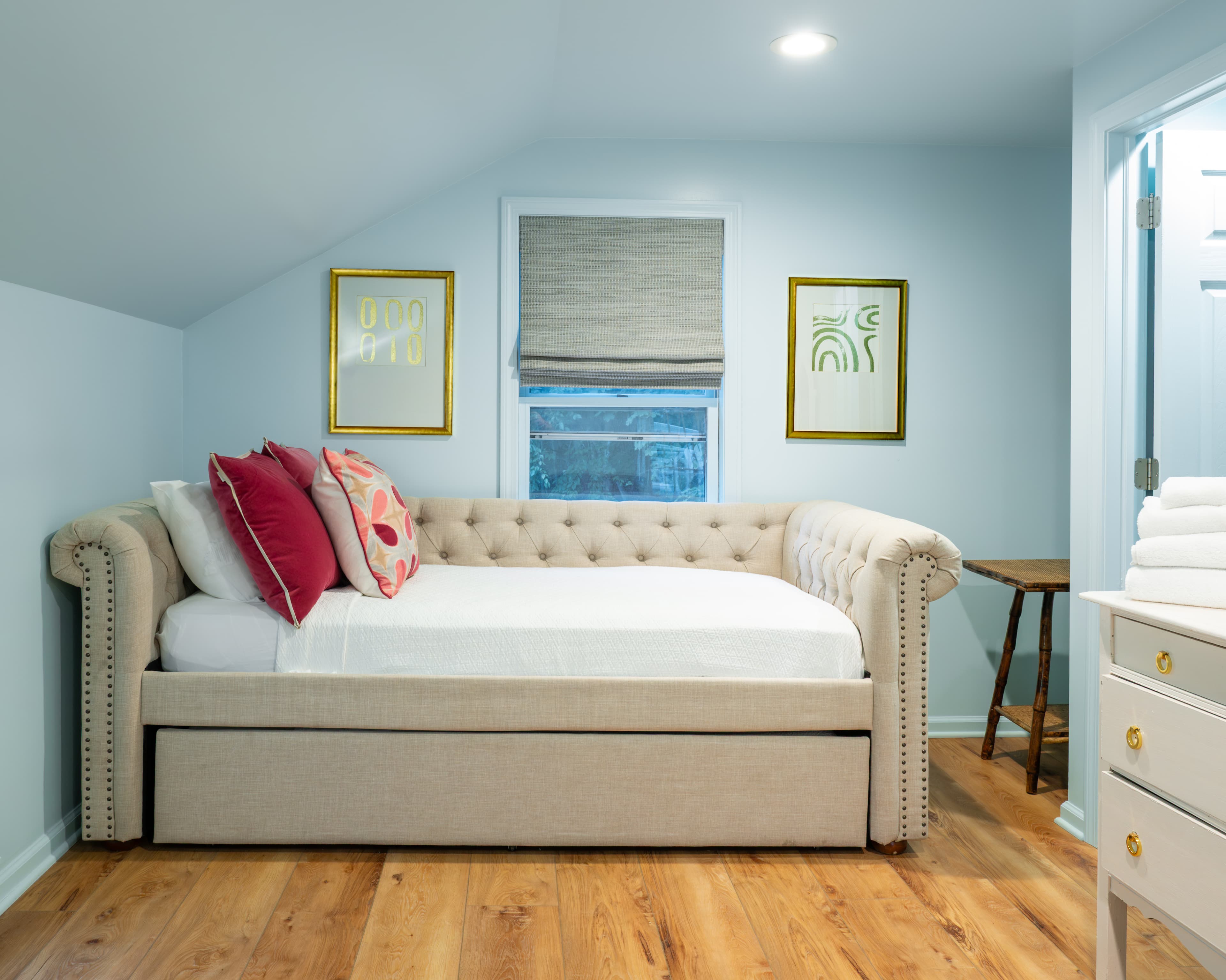 Cozy bedroom featuring a plush daybed with decorative pillows and light blue walls.