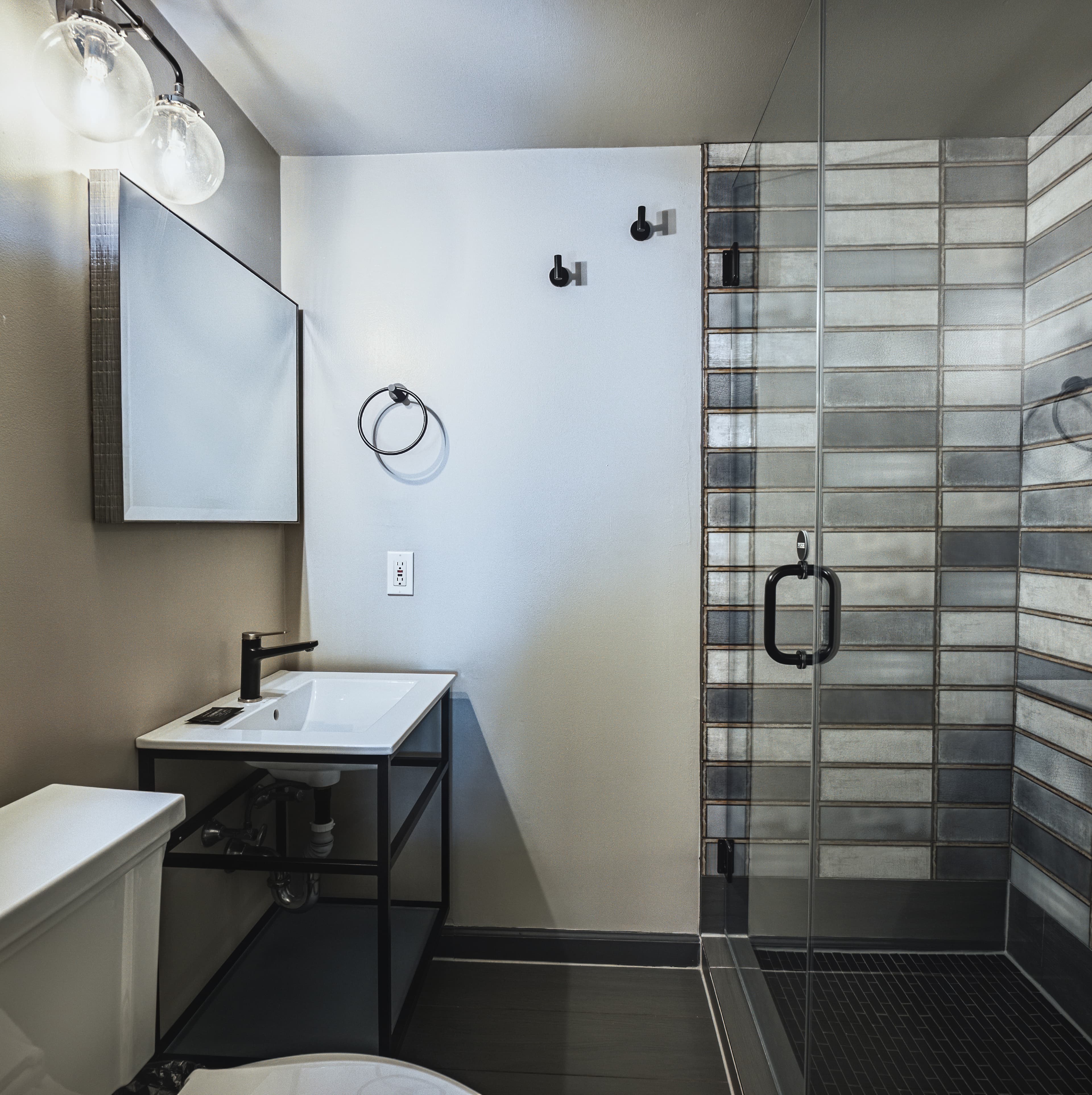 A modern bathroom featuring a glass shower, sleek vanity, and minimalist decor.