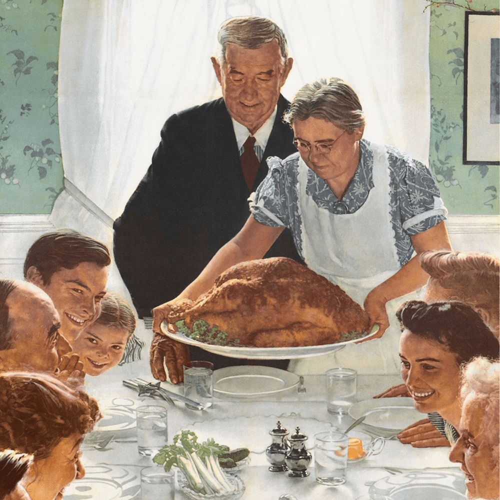 A family gathers around a table eagerly as a woman presents a large roasted turkey.